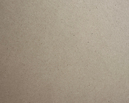 A close-up texture shot of a light brown eco paper surface with fine speckles and a matte finish.